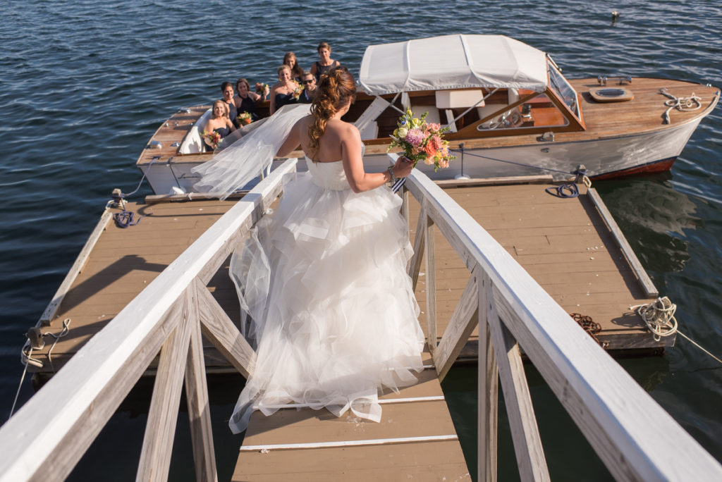 Bride walking down dock to the boat.