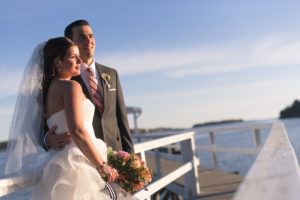 Bride and groom posing on the dock.