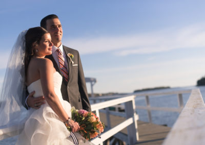 Bride and groom posing on the dock.