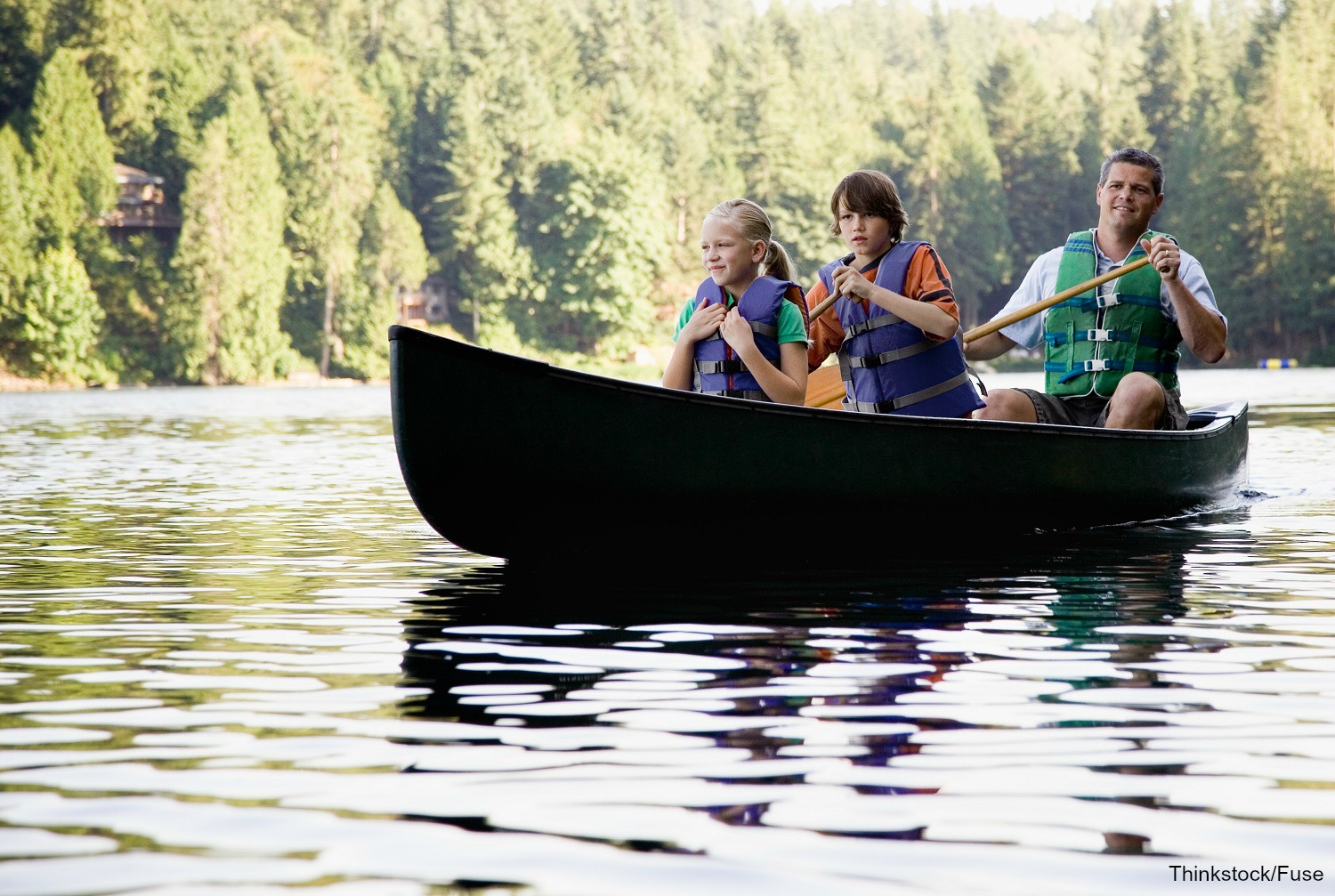 Dad and children in a canoe.