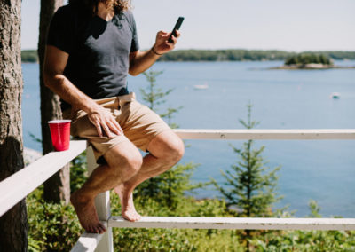 Man sitting on balcony with phone.