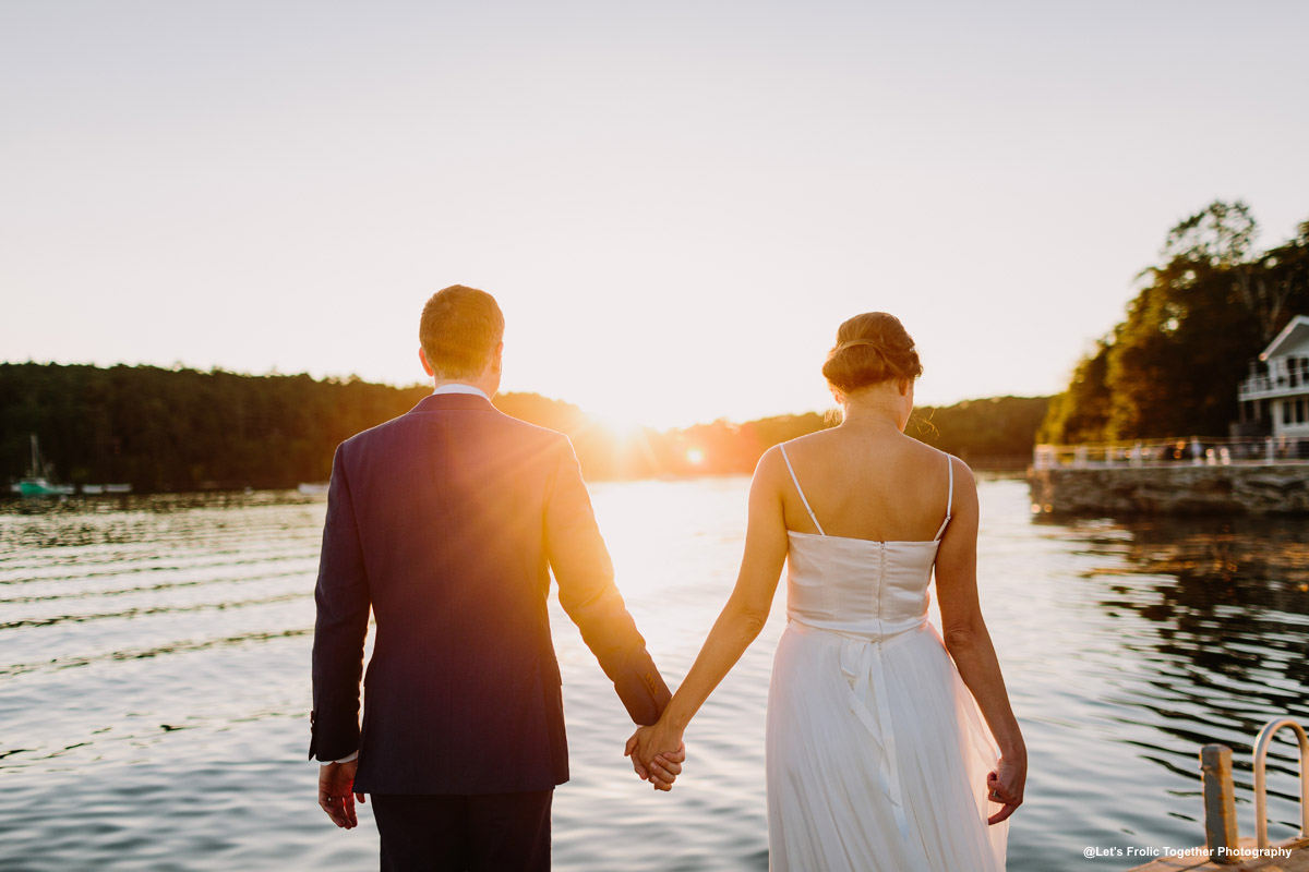 Bride and Groom on the bay holding hands at sunset.