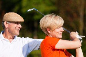 Couple playing golf during adventure travel for seniors