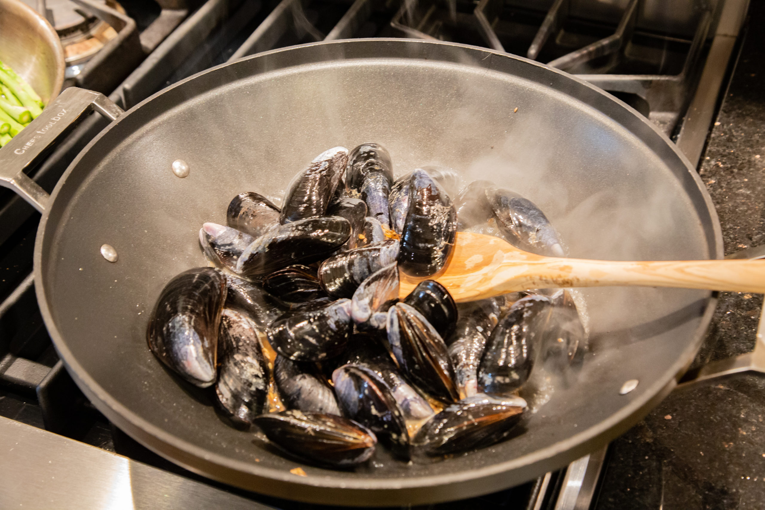 Mussels being mixed with other ingredients.