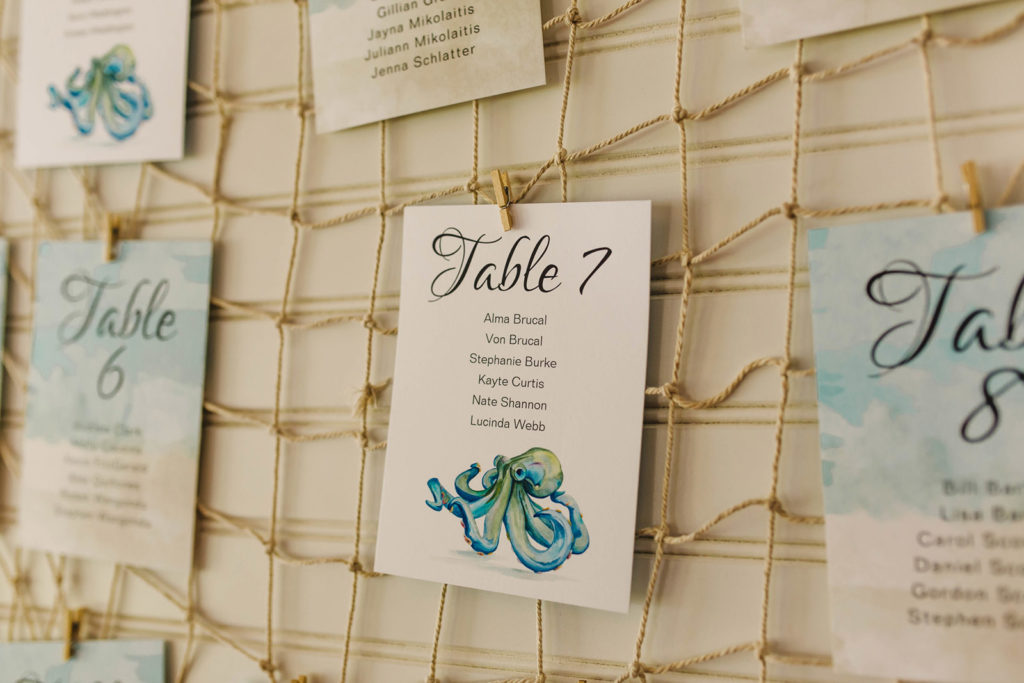 Kylie and Po's wedding reception table assignments hanging on fishing net