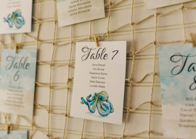 Kylie and Po's wedding reception table assignments hanging on fishing net