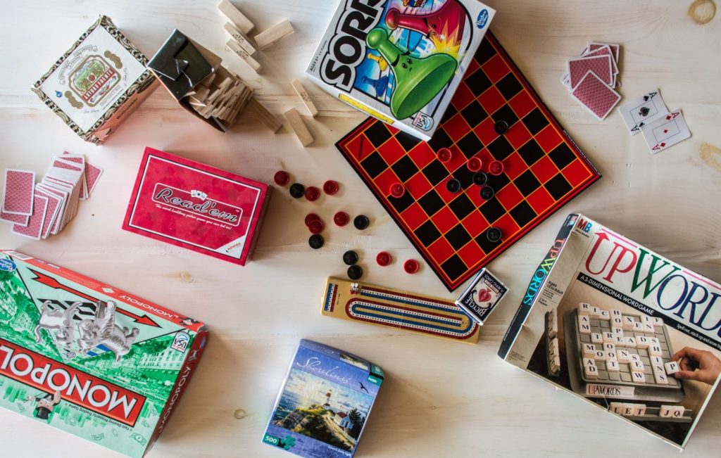 Collection of board games: Sorry, checkers, jenga, playing cards, UpWords, Monopoly.