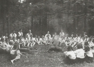 Young women around a campfire.