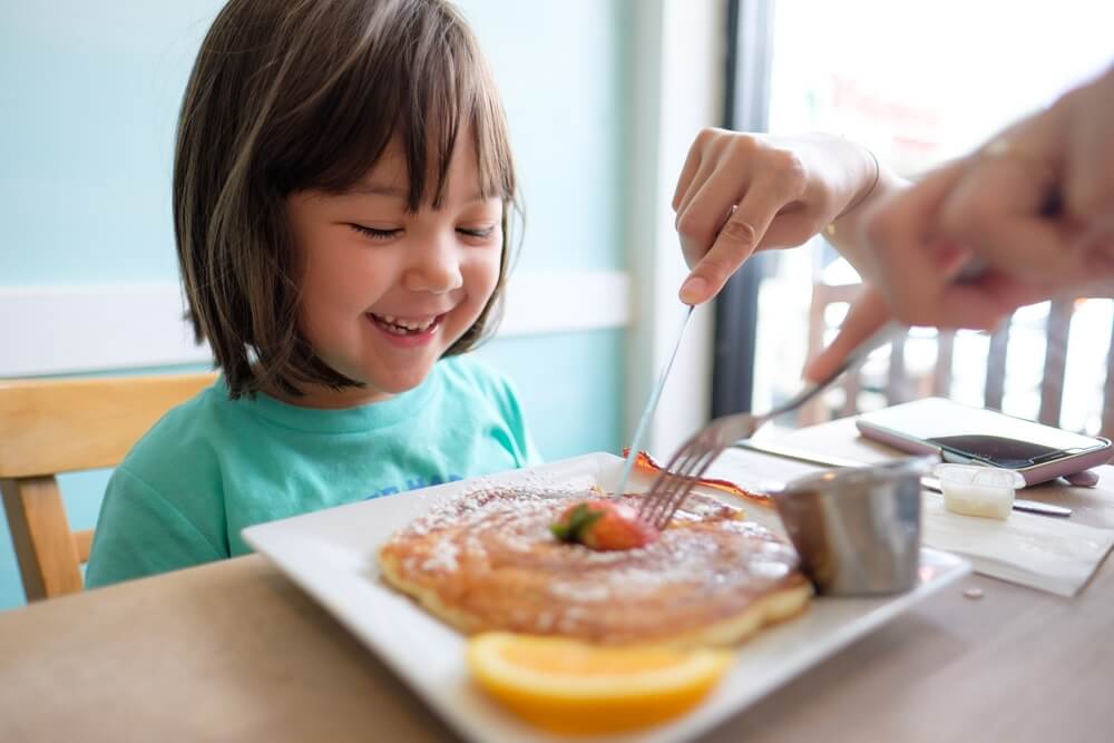 A photo of a young girl having a pancake for breakfast a Boothbay Harbor spot.