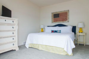 The bedroom of a Boothbay Harbor resort room to relax and check the weather in.