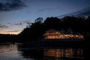 The lakefront of a Boothbay Harbor resort filled with charming rentals at night.