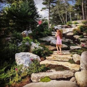 A girl walking the grounds of a resort that's close to the botanical garden in Boothbay, Maine.